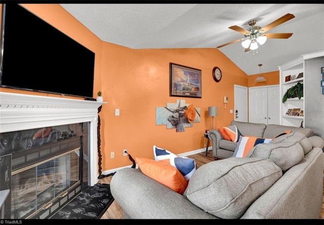 living room featuring ceiling fan, built in features, wood-type flooring, and vaulted ceiling