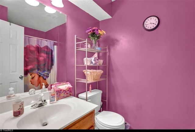 bathroom featuring a shower with shower curtain, vanity, and toilet