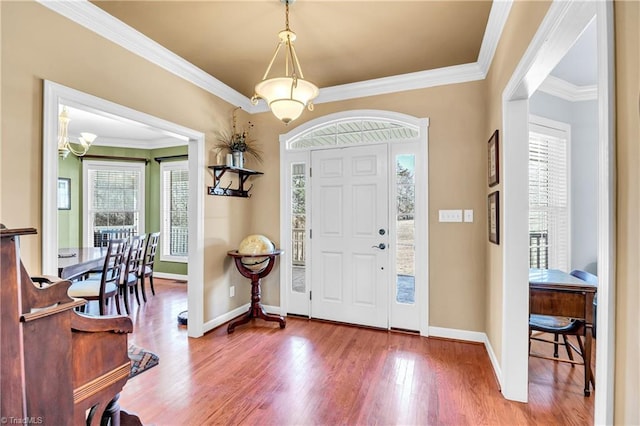 entrance foyer featuring baseboards, ornamental molding, and wood finished floors