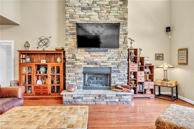 living area featuring a fireplace, wood finished floors, and baseboards