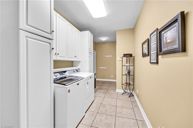 washroom featuring light tile patterned flooring, washing machine and dryer, cabinet space, and baseboards