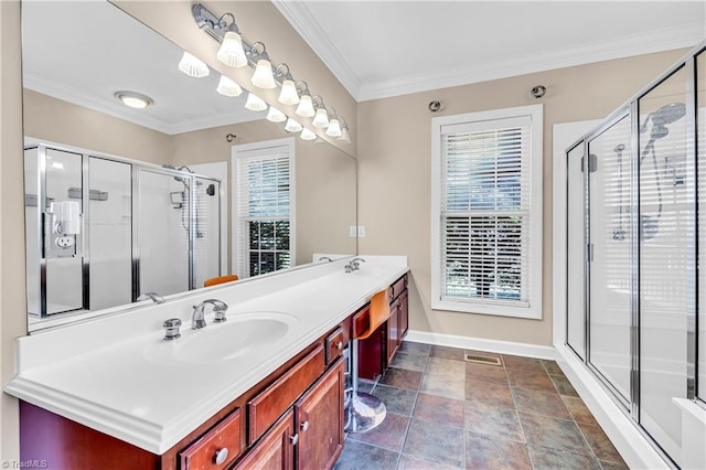 full bathroom with double vanity, a stall shower, crown molding, and a sink