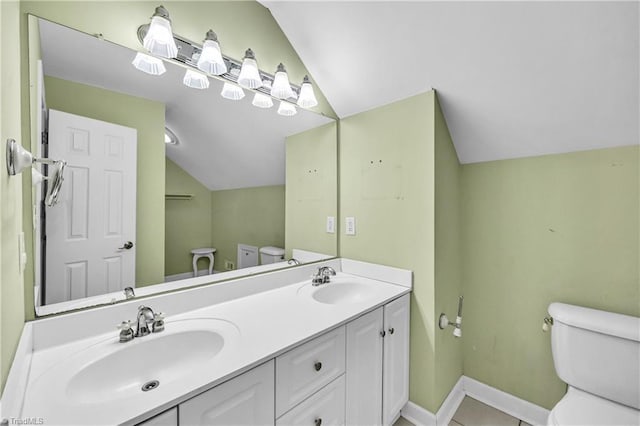 bathroom with vaulted ceiling, a sink, and toilet