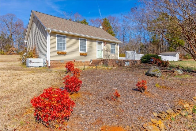 view of front of home featuring crawl space, central AC, and roof with shingles