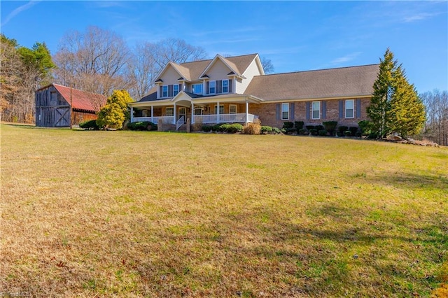 view of front of home featuring a porch, an outbuilding, a front lawn, and a shed