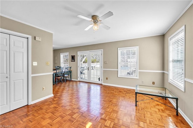 foyer with crown molding, french doors, a ceiling fan, and baseboards