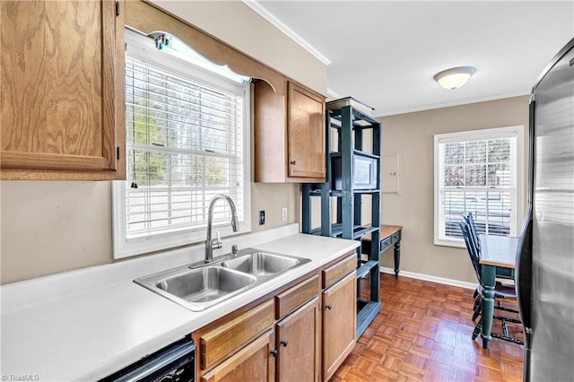 kitchen featuring light countertops, brown cabinets, a sink, and crown molding