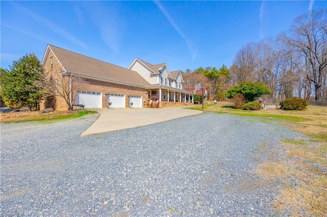 view of front of house featuring driveway, brick siding, and an attached garage