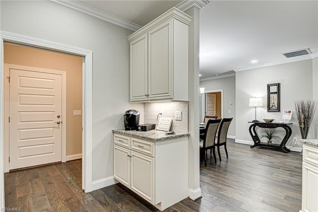 kitchen featuring crown molding, decorative backsplash, dark hardwood / wood-style floors, and light stone counters