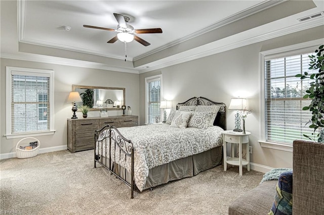 carpeted bedroom featuring ornamental molding, a tray ceiling, and ceiling fan