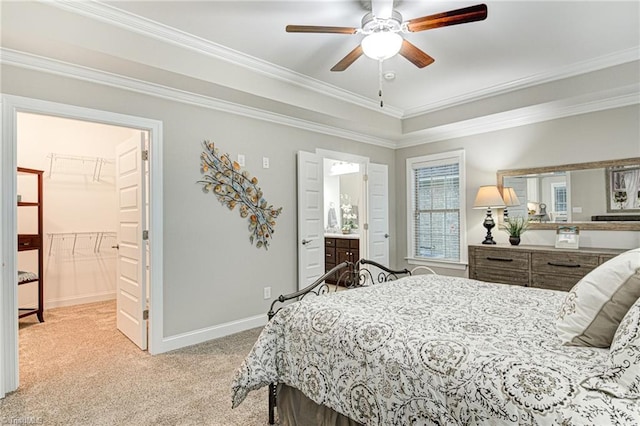 carpeted bedroom with a closet, ornamental molding, ensuite bath, a spacious closet, and ceiling fan