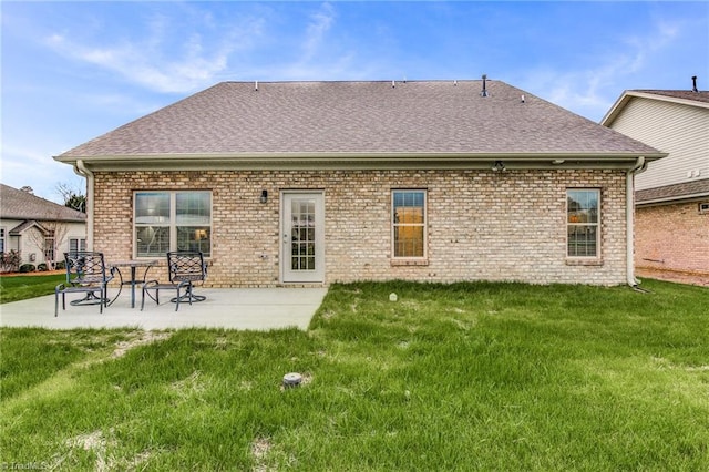 back of property with a lawn and a patio area