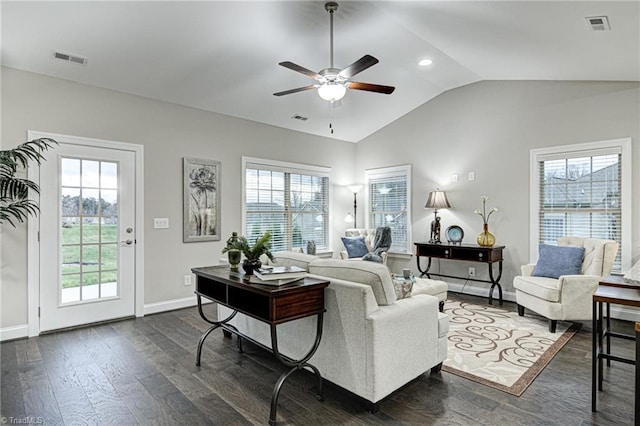 living room featuring lofted ceiling, dark wood-type flooring, and a wealth of natural light