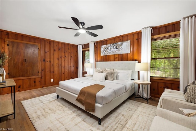 252 Lucerne Ln NW, Winston-Salem, NC 27104 - bedroom featuring wood walls, ceiling fan, and light wood-style flooring
