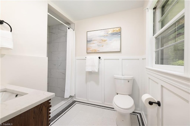 252 Lucerne Ln NW, Winston-Salem, NC 27104 - bathroom with a decorative wall, vanity, toilet, a tile shower, and a wainscoted wall
