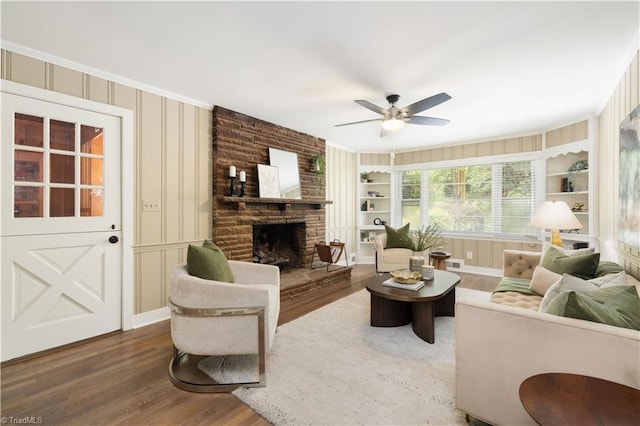 252 Lucerne Ln NW, Winston-Salem, NC 27104 - living area featuring wood finished floors, built in shelves, a ceiling fan, ornamental molding, and a stone fireplace