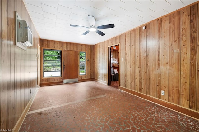 252 Lucerne Ln NW, Winston-Salem, NC 27104 - spare room with baseboards, wood walls, a ceiling fan, an AC wall unit, and stone finish floors