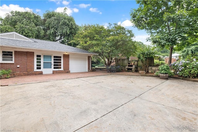 252 Lucerne Ln NW, Winston-Salem, NC 27104 - view of side of property featuring an attached garage, brick siding, driveway, and roof with shingles