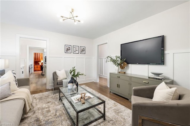 252 Lucerne Ln NW, Winston-Salem, NC 27104 - living area with wood finished floors, a chandelier, a wainscoted wall, and a decorative wall