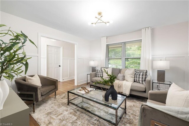 252 Lucerne Ln NW, Winston-Salem, NC 27104 - living area featuring a decorative wall, wood finished floors, a wainscoted wall, and a chandelier