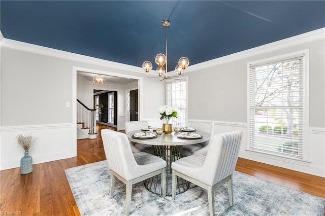 dining room featuring ornamental molding, plenty of natural light, a chandelier, and hardwood / wood-style flooring