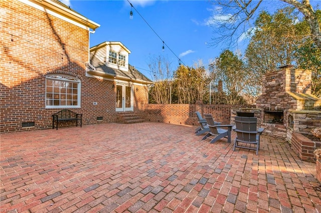 view of patio featuring french doors and an outdoor stone fireplace