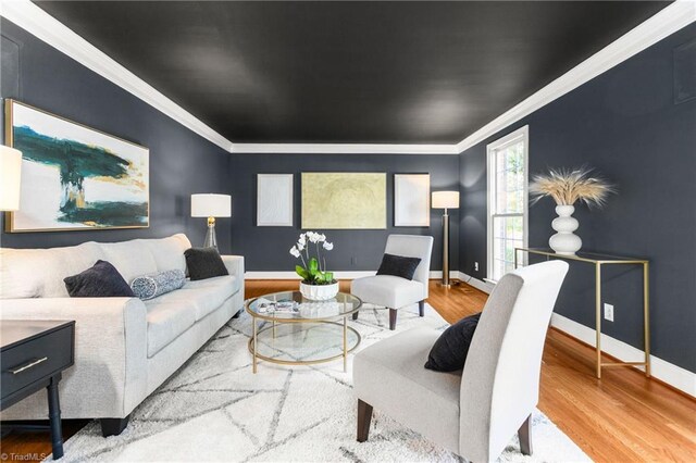 living room with crown molding and light hardwood / wood-style floors