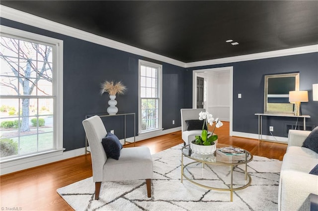 living room with ornamental molding, a wealth of natural light, and light hardwood / wood-style flooring