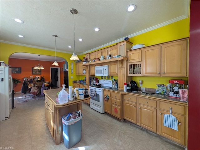 kitchen with arched walkways, a center island, decorative light fixtures, ornamental molding, and white appliances