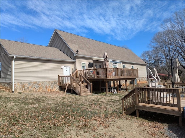 rear view of house with a wooden deck and roof with shingles