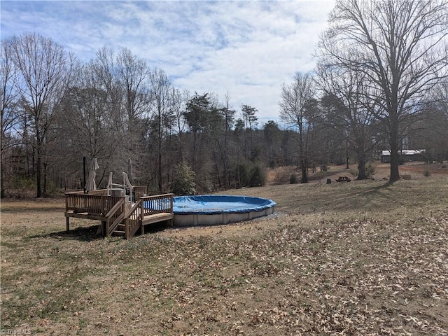 view of yard with a covered pool and a deck