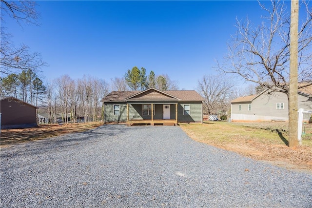 view of front of property with a porch and gravel driveway