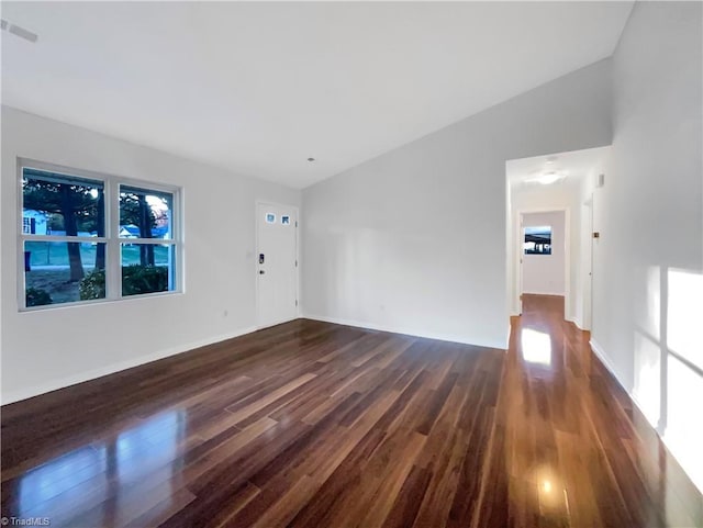 empty room featuring dark wood-type flooring and vaulted ceiling