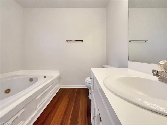 bathroom featuring vanity, hardwood / wood-style flooring, toilet, and a bathtub