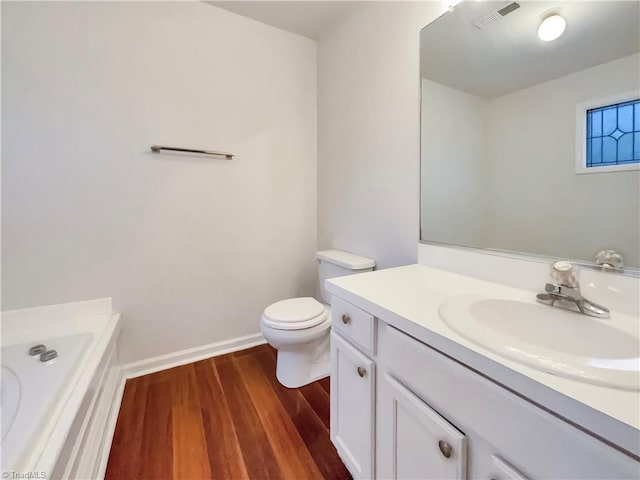 bathroom featuring toilet, vanity, and hardwood / wood-style flooring