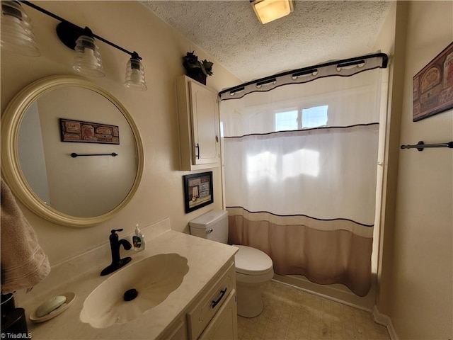 bathroom with vanity, toilet, and a textured ceiling