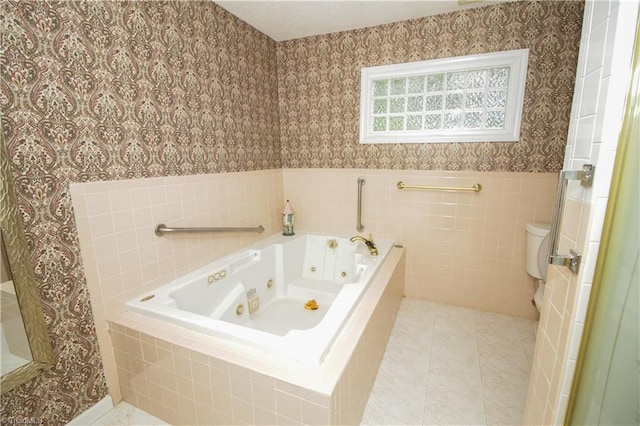 bathroom with wallpapered walls, toilet, a jetted tub, wainscoting, and tile patterned flooring