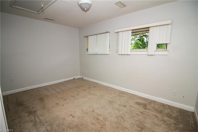 empty room featuring carpet floors and baseboards