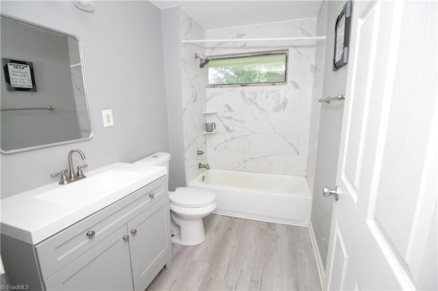 bathroom featuring toilet, vanity, wood finished floors, and shower / tub combination