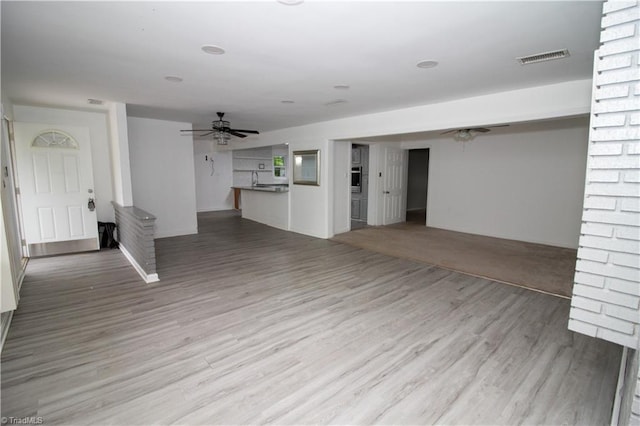 unfurnished living room with ceiling fan and wood finished floors