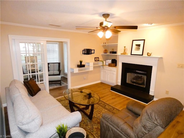 3982 Westridge Meadow Cir, Clemmons, NC 27012 - living area featuring wood finished floors, ornamental molding, ceiling fan, baseboards, and a glass covered fireplace