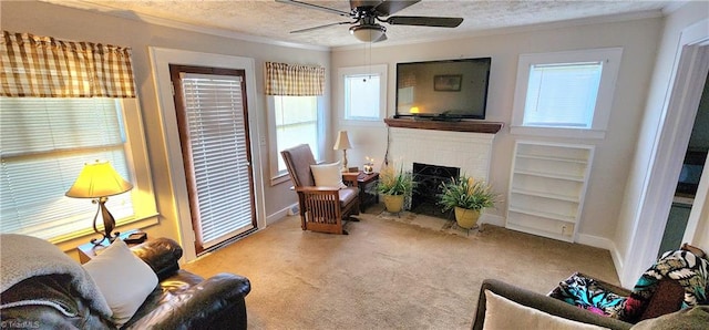 carpeted living room featuring ceiling fan, a fireplace, ornamental molding, and a textured ceiling