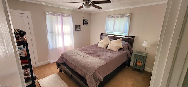 bedroom featuring ceiling fan, light carpet, a closet, and crown molding