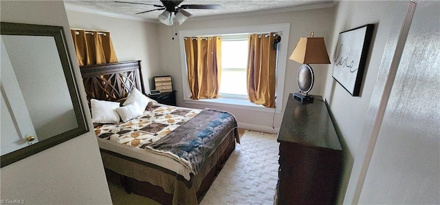 bedroom featuring ceiling fan, a textured ceiling, and ornamental molding