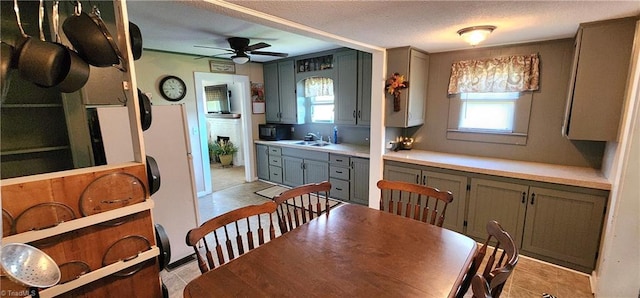 kitchen with ceiling fan, sink, and a textured ceiling