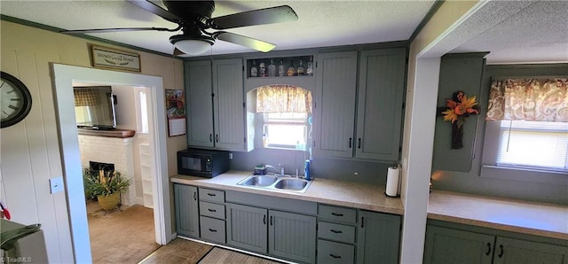 kitchen with ceiling fan, a wealth of natural light, sink, and a textured ceiling