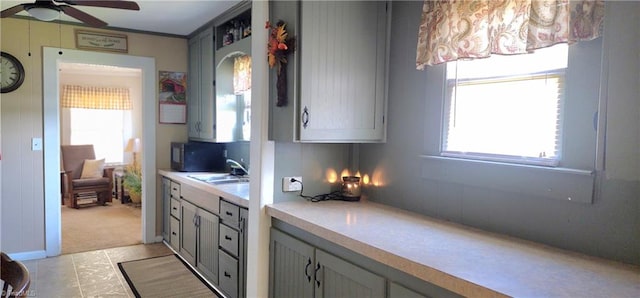 kitchen featuring ceiling fan, light tile patterned floors, sink, and gray cabinetry