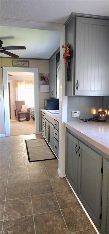 kitchen featuring ceiling fan and gray cabinetry