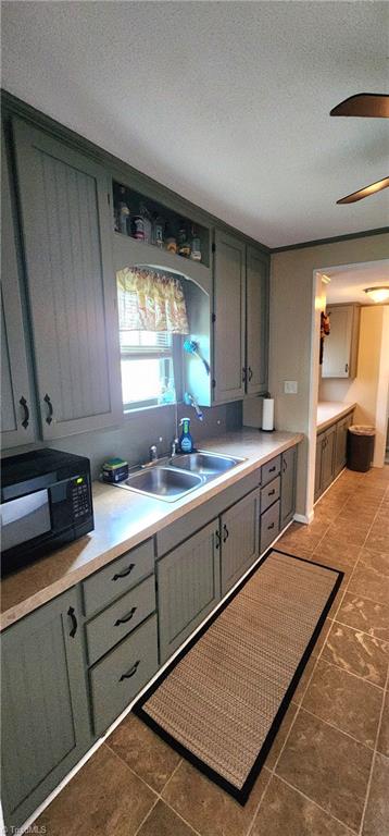 kitchen with a textured ceiling, ceiling fan, and sink