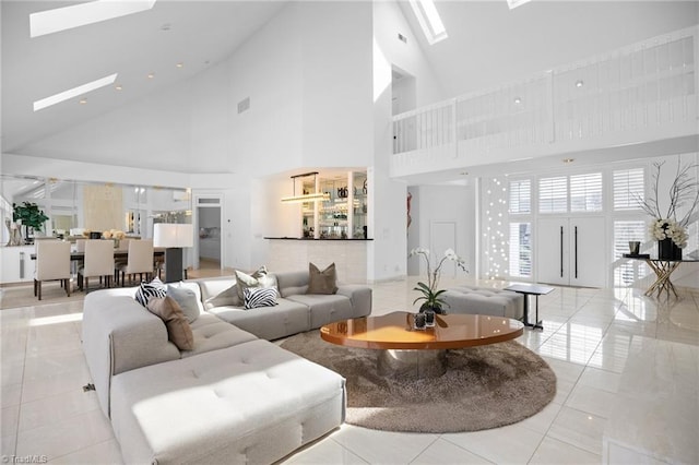 tiled living room featuring a skylight and visible vents